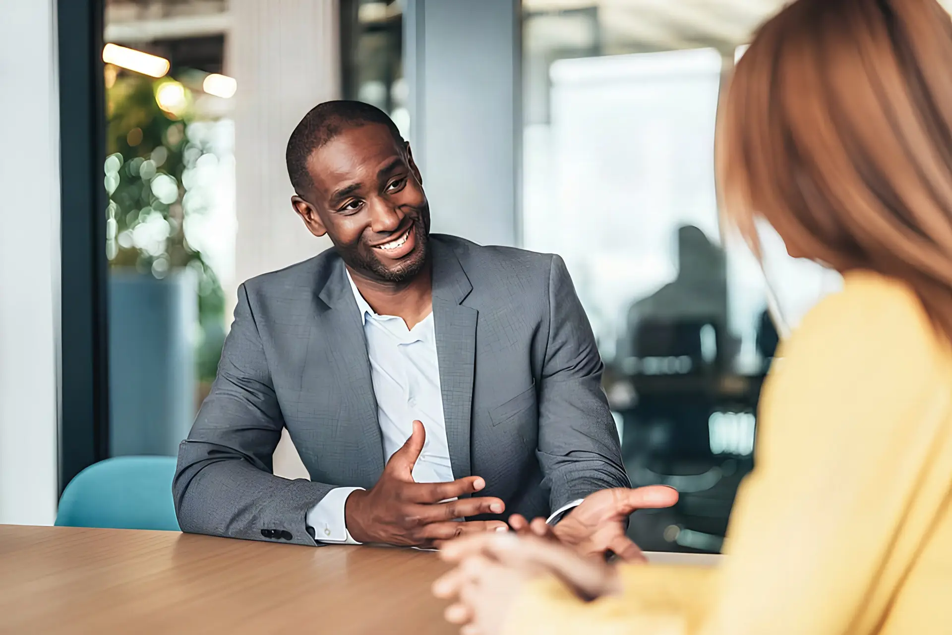 Black male ACC-credentialed coach listening attentively during a 1:1 coaching session in a modern office.