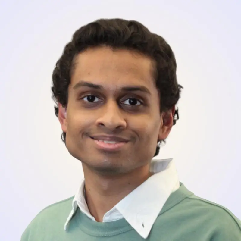 Pardhu Namburi, CTO at Coacharya, smiling in a green sweater over a white collared shirt
