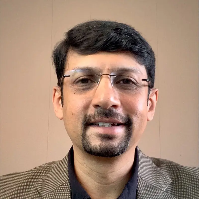 Shesh Vasudevamurthy, Executive Director at Coacharya Foundation, in a checked blazer over a dark shirt