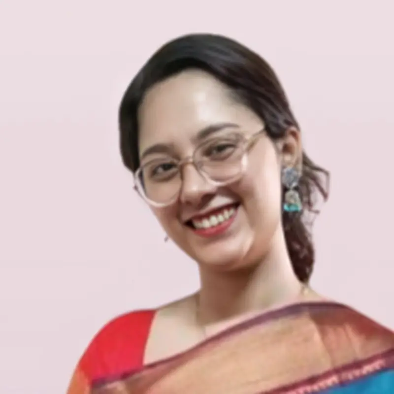 Chinnu Yesudas, Coacharya team member, smiling in a blue silk saree