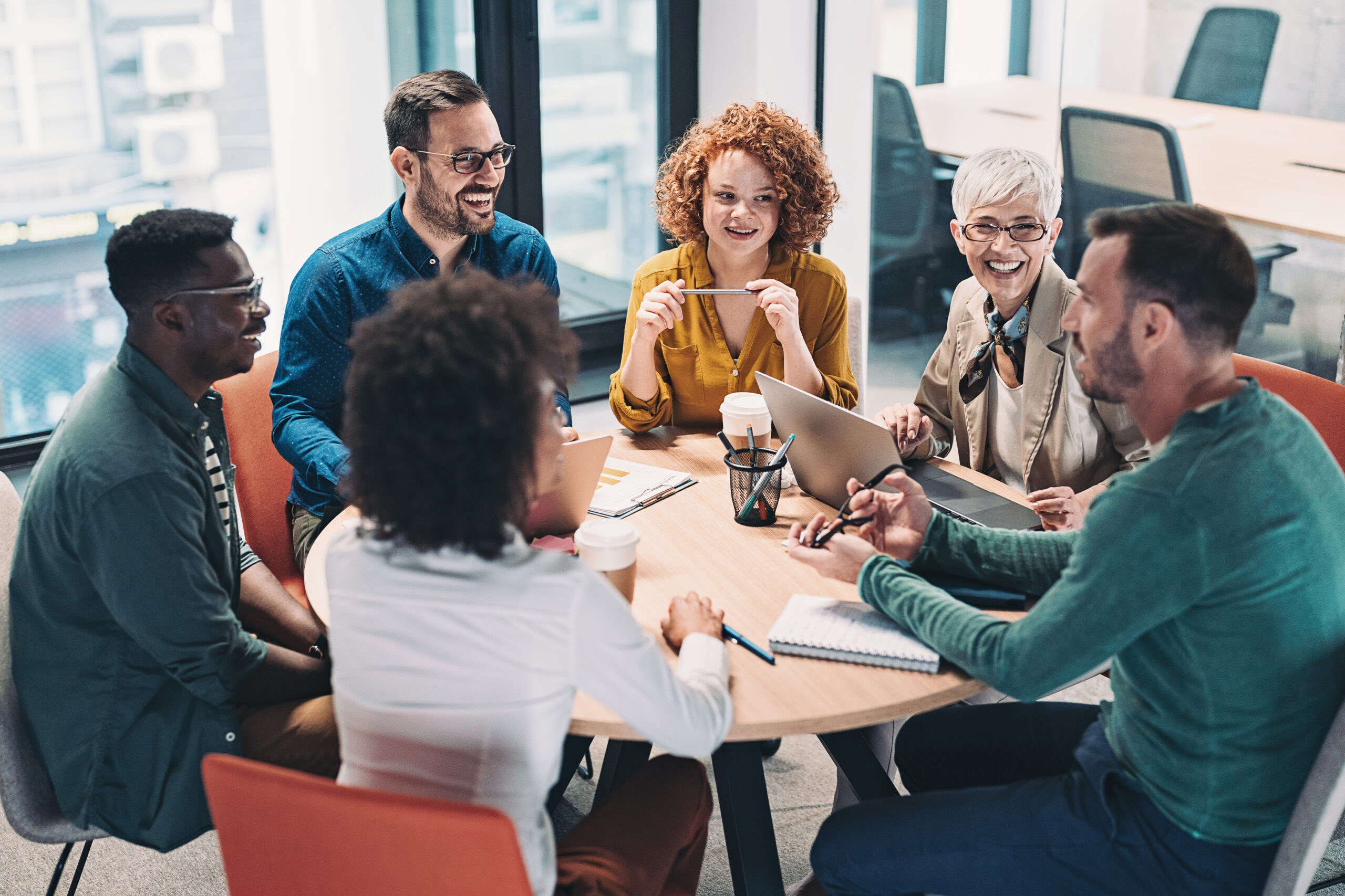 Diverse team in discussion around a table during a team coaching session